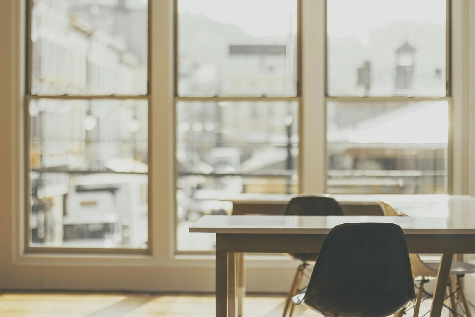 Leere Schreibtische und Stühle in einem hellen Büro – Sinnbild für die Entscheidung zwischen neuer Stelle und externer IT-Abteilung