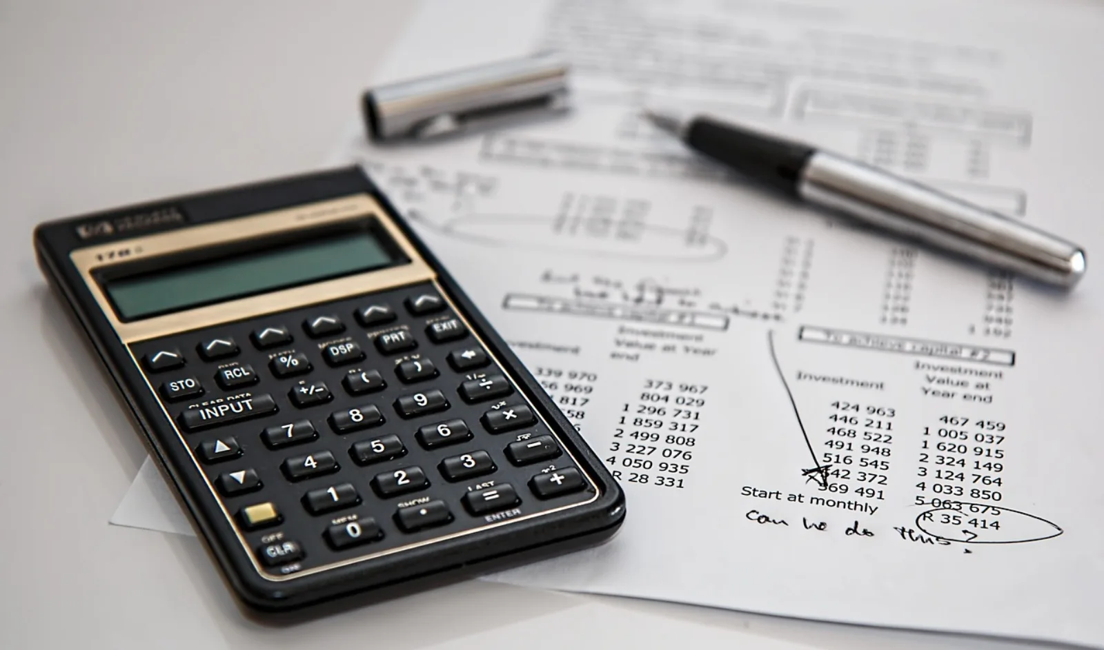Taschenrechner und Kostenaufstellung auf einem Schreibtisch – IT-Budget im Mittelstand planen