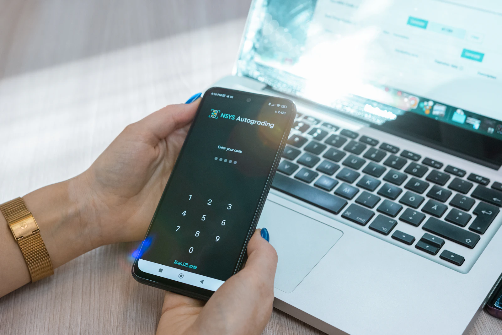 Smartphone mit Authentifizierungs-App neben Laptop – MFA im Unternehmen einführen
