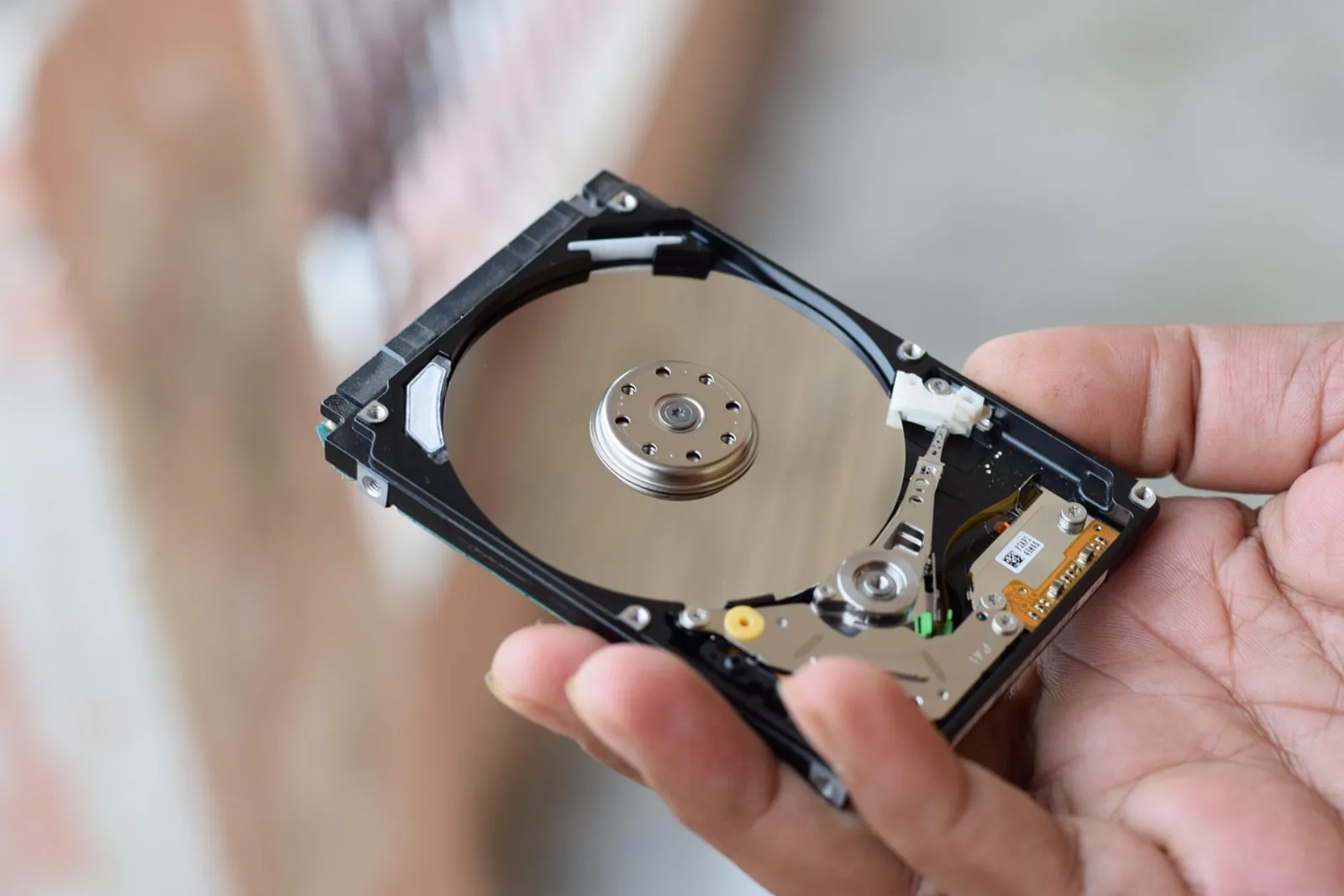 Geöffnete Festplatte in einer Hand – Sinnbild für den Microsoft 365 Backup Vergleich