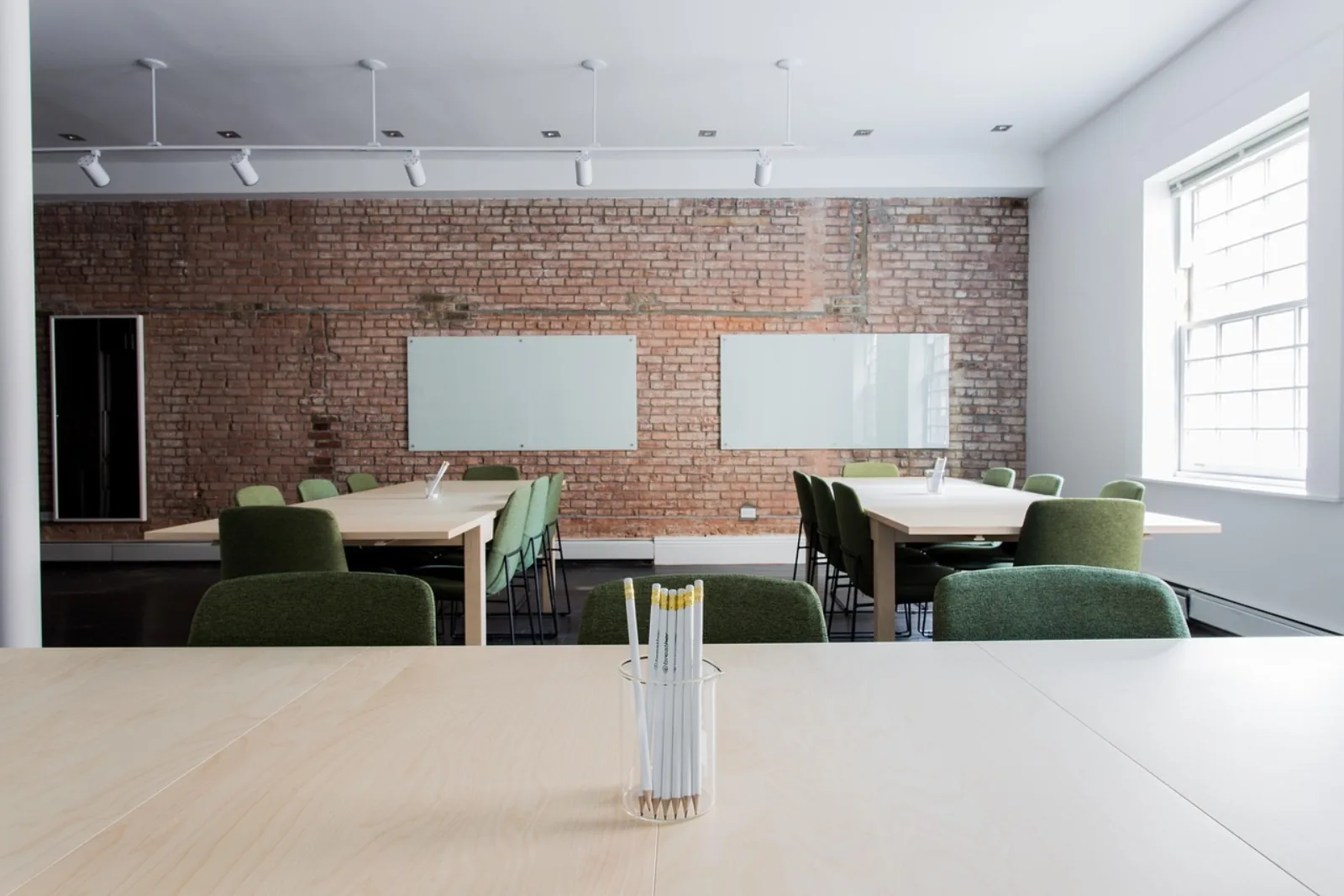Leerer Schulungsraum mit Tischen und Whiteboards – Security-Awareness-Training im Vergleich