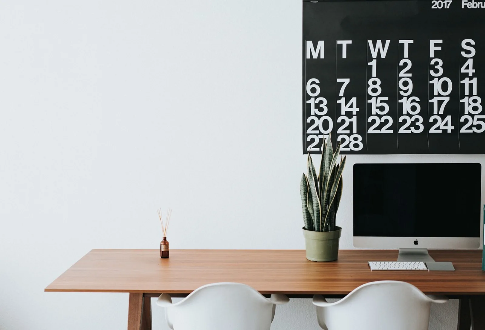 Aufgeräumter Büroarbeitsplatz mit Monitor – der Zustand, den ein IT-Helpdesk aufrechterhält